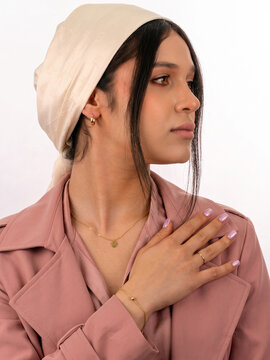 Young Woman Wearing Headscarf with Hand on Chest on White Background