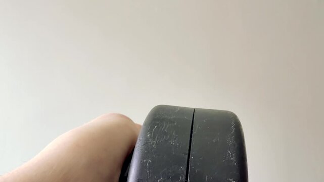 Hand Pulling Yellow Tape Measure from Black Casing