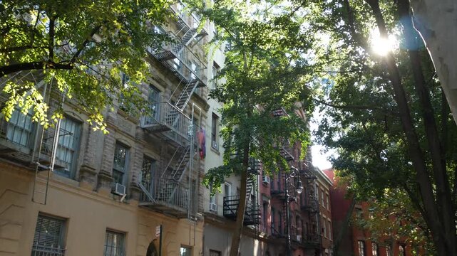 New York City urban residential buildings architecture, Manhattan classic street, United States of America. Typical red brick house in NYC, real estate property in USA. Fire escape metallic ladder.