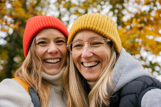 A mature woman and a friend take a selfie during a fall hike