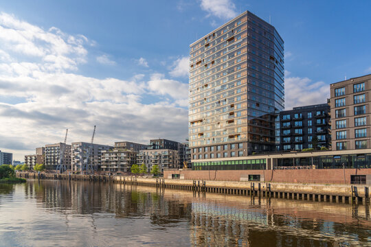 The modern Roots building reflects in the HafenCity river