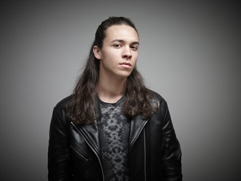 Portrait of young man standing grey background