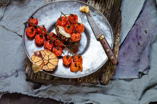 Roasted tomatoes, crostini with goat cheese, garlic on plate