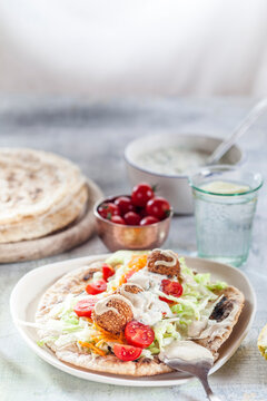 Falafel with salat on homemade flat bread with tahini sauce