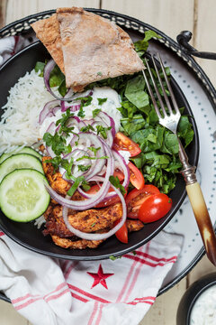 Gyros, rice, chicken, salad, tomato, cucumber, onion, tzatziki, homemade pita bread