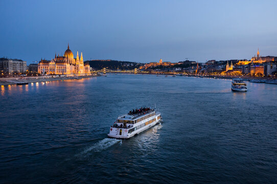 Hungary, Budapest, tourist boats on river danube, parliament building in the background