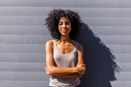 Portrait of content young woman with curly hair in summer