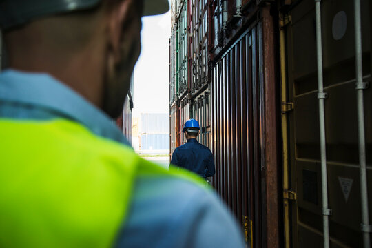 Two men with safety helmets at container port