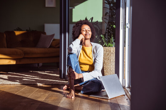 Woman relaxes on the floor with a notebook in the sunlight