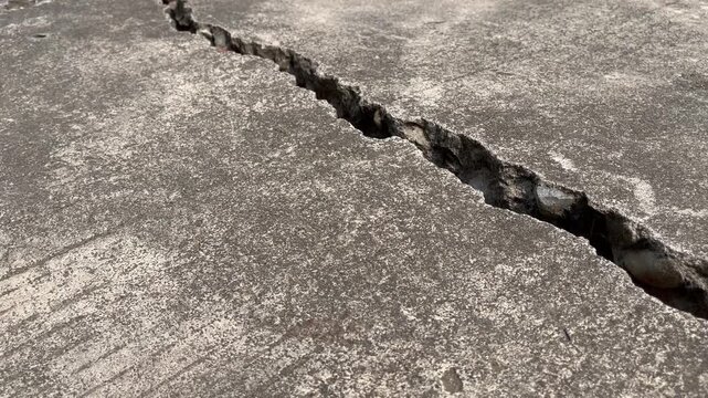Dramatic earthquake crack split on weathered concrete road