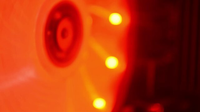 Spinning computer cooling fan with red led illumination. Hardware component rotating inside gaming system. Modern electronic equipment for pc heat dissipation process.