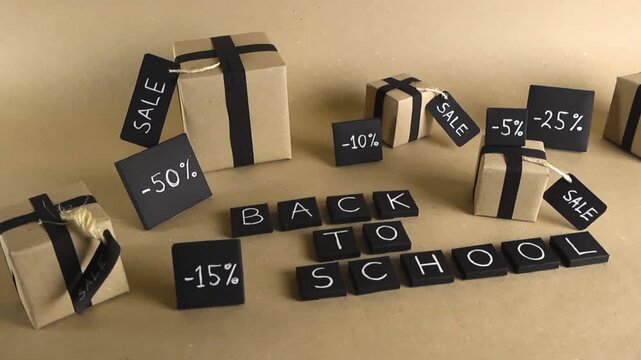 Creative back to school sale concept with handcrafted gift boxes, black ribbons, and percentage discount signs on a light brown paper background, promoting special student offers