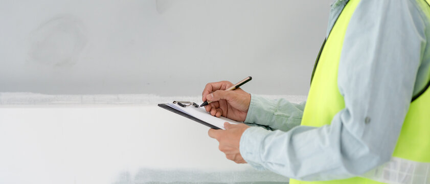 inspector or engineer is inspecting construction and quality assurance new house using a checklist. Engineers or architects or contactor work to build the house before handing it over to the homeowner