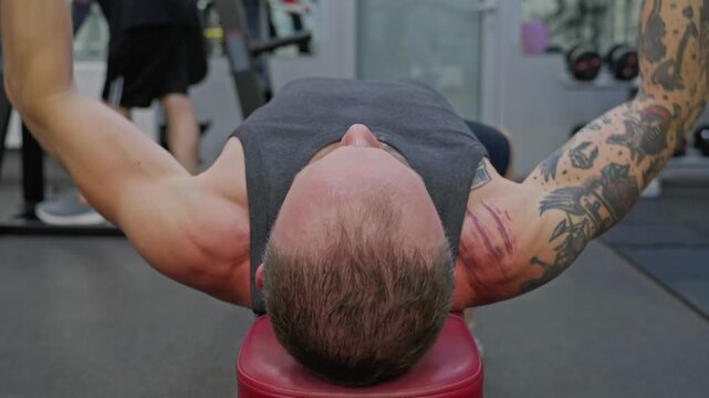 A man is performing a bench press in the gym