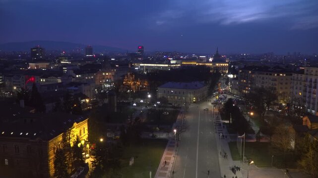 Blue hour cityscape of central Sofia from the Alexander Nevsky Cathedral bell tower, showing the square, Holy Synod building, urban skyline and Vitosha Mountain.
