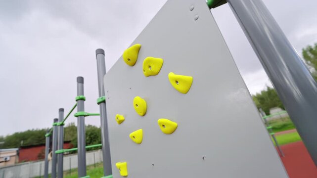 Climbing grips offer physical challenges on school sports ground. This professional infrastructure encourages active play and fitness