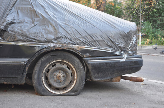 Damaged car covered with plastic tarp