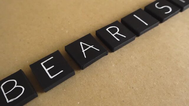 Smooth camera movement gliding over black tiles spelling the word bearish, representing a downward trend in the stock market, pessimistic outlook, and financial investment recession concept