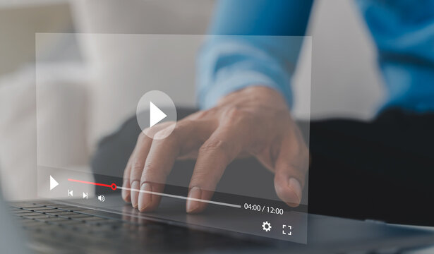 Close up of businessman hand using laptop with virtual video player interface. Professional watching online video streaming on digital media platform. Webinar, distance learning and VOD concepts