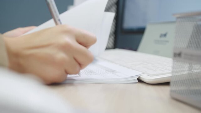 Office worker flips white paper pages on wooden table. Motion blur dynamic effect highlights fast business documentation review process