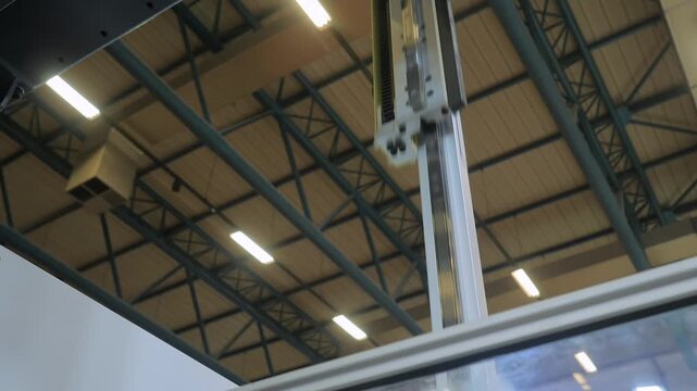 Automatic pick and place robotic arm manipulator with suction cups moves white polypropylene yogurt containers: plastic injection molding machine at exhibition, factory - close up view