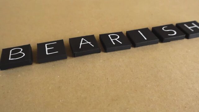 Smooth camera movement in front of black paper folded squares with letters spelling the word bearish, representing a pessimistic outlook on the financial markets and a downward price trend