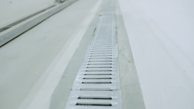 Industrial ventilation grate installed flush with polished concrete floor surface. Clean installation provides efficient air circulation
