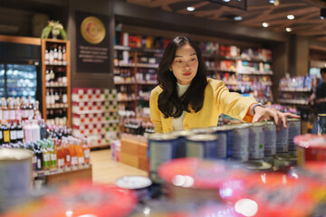 Obraz premium Woman shopping for products in a modern supermarket
