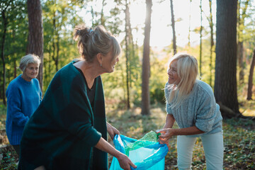 Obraz premium Senior women volunteering for nature protection and litter collection.