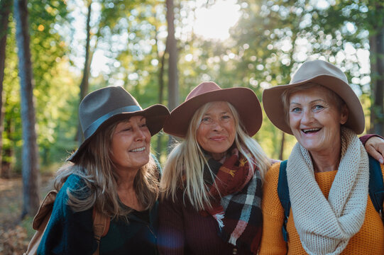 Group of elderly female friends enjoying woodland foraging adventure.