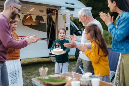 Multigenerational family celebrating girls birthday during camper vacation.