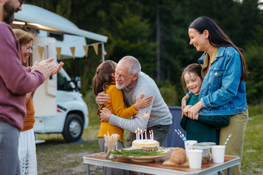 Multigenerational family celebrating girls birthday during camper vacation.