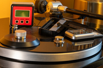 Record turntable vinyl player accessories showing a collection of brushes, scales, level, record clamp and spike feet. © alexander
