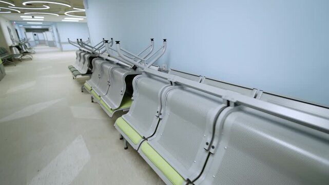 Rows of new medical benches stand inverted along light blue corridor wall. Pristine facility interior feels quiet and completely vacant