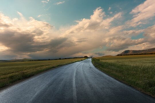 clearing up of dramatic sky after the rain on rural road of Sicily at the sunset in Italy