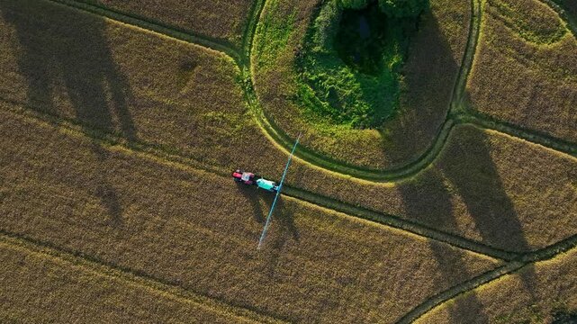 Aerial Top Down View of Tractor Spraying Field around a Wet Woodland Pond