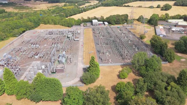 An aerial pull back drone movement of Bushbury Grid Supply Point, a large scale electrical substation in Wolverhampton, UK revealing the rural setting