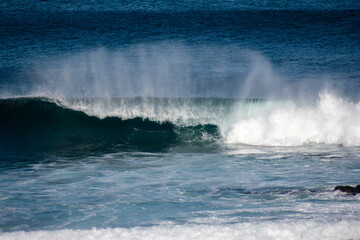 Naklejka premium Breaking wave throws up plume of sea spray at ANZACs Beach, Phillip Island, Victoria, Australia.