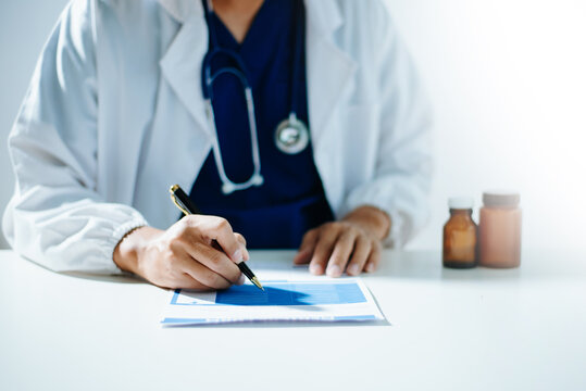 Doctor using smartphone and laptop for telemedicine consultation, mobile healthcare technology, digital health communication, and modern medical