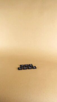 Black letter tiles spelling out the words 'job loss' on a neutral light brown background, representing the concept of unemployment, financial crisis, and economic recessionary period