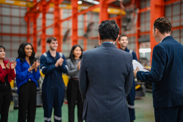 Fototapeta premium Business managers address factory workers during employee meeting, representing leadership, staff communication, teamwork, manufacturing management, employee recognition.