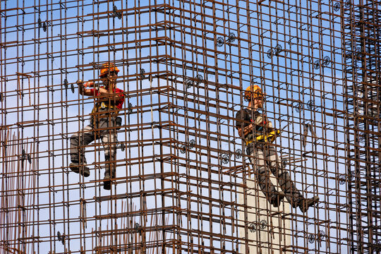 Two workers installers on construction site. Housing construction, builders working on scaffolding