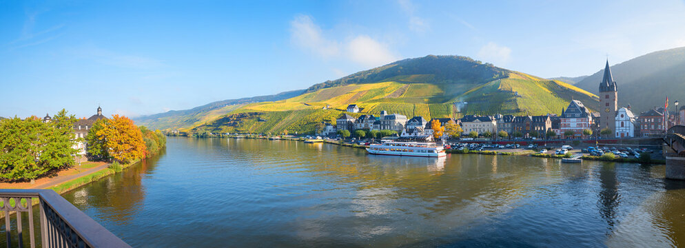 view from bridge to Moselle river with ship, tourist resort Bernkastel and vineyards in autumn