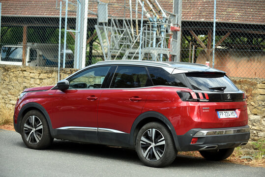 St - Amand Montrond - France - 9 August 2026 - Three quarter rear view of a red Peugeot 3008 SUV parked on a street, showing a modern French vehicle in an urban environment.
