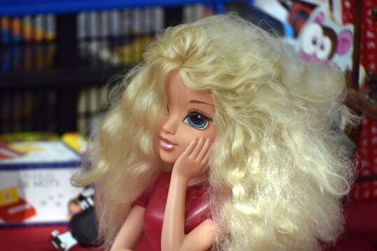 Hair styling doll head displayed among second hand objects at a flea market, representing a vintage beauty toy associated with childhood and creative play.
