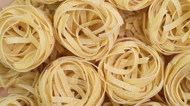 Raw pasta tagiatelle close-up, top view