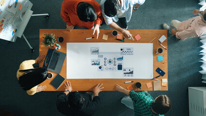 A diverse group of professionals engages in a strategy meeting, analyzing data and sharing ideas...