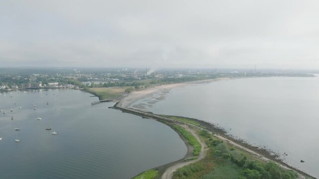 Drone footage of Black Rock Harbor Lighthouse located in Bridgeport Connecticut during early morning spring time from behind going forwards overlooking the beach