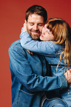 A tender father and daughter moment with a warm hug in a studio portrait