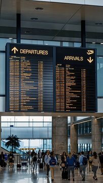 Busy airport terminal with digital departure boards and travelers.